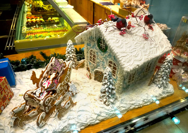 Gingerbread house and sleigh with deer, showcase confectionery shop, night in the new year. - Photo, Image