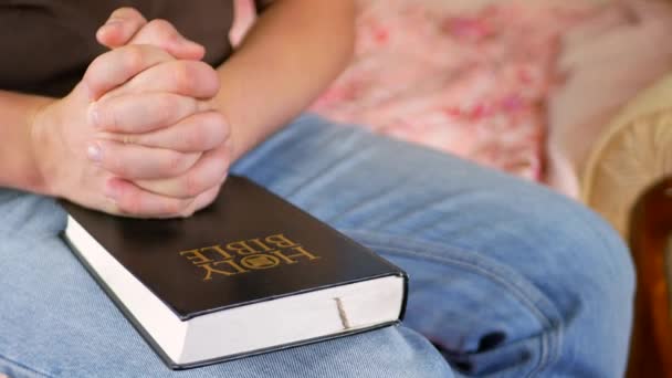 Homem orando segurando uma Bíblia Sagrada em casa
 - Filmagem, Vídeo