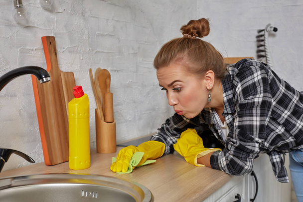 Young woman washing manually, by hand, wearing yellow cleaning rubber gloves. - Photo, Image