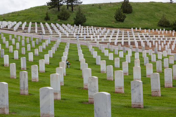 Σειρές από λευκό μάρμαρο μνήματα σήμανση σοβαρές περιοχές μας στρατιωτών στην πλαγιά του λόφου του τα καυτά ελατήρια Εθνικό νεκροταφείο στη Νότια Ντακότα. - Φωτογραφία, εικόνα