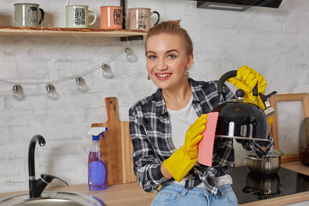 Hauswirtschaftskonzept, glückliche blonde Dame putzt Wasserkocher. - Foto, Bild