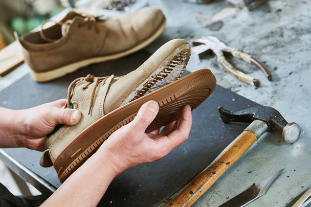 Shoemaker repair shoe. Glueing the sole for male footwear - Fotoğraf, Görsel