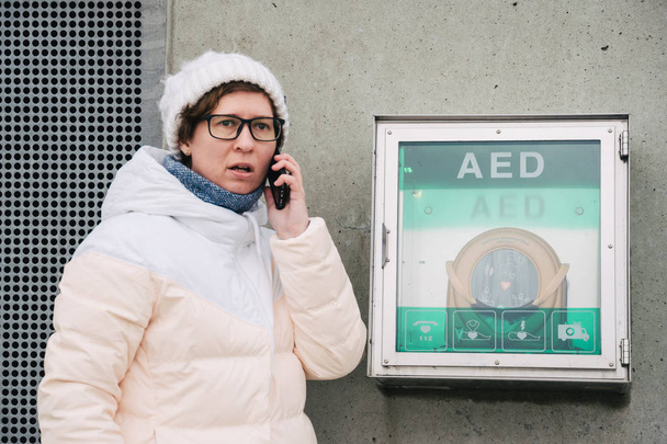 medicine cardiopulmonary resuscitation emergency call. Caucasian woman uses telephone calling 911 help. device box aed automatic defibrillator diseases, clinical death, cardiac arrest and heart attack - Photo, Image