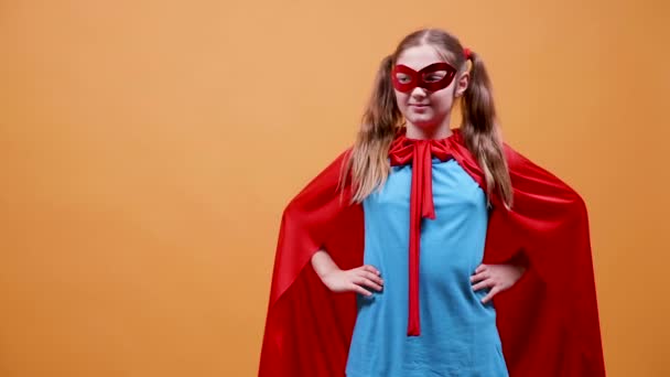 Młoda dziewczyna ubrana w kostium superbohatera, podniesienie jej pięść - Materiał filmowy, wideo