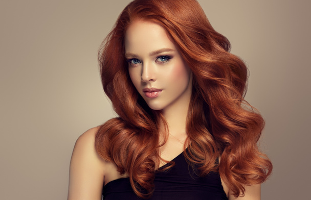 Jeune femme rousse aux cheveux volumineux.Beau modèle à la coiffure longue, dense et bouclée
 - Photo, image