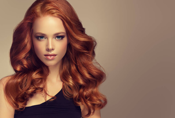 Μικρά, κόκκινα μαλλιά γυναίκα με ογκώδη μαλλιά. Το όμορφο μοντέλο με μακρύ, πυκνό, σγουρά χτένισμα - Φωτογραφία, εικόνα