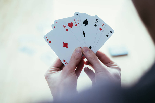 Young man is playing cards, cutout of his hands - Foto, afbeelding