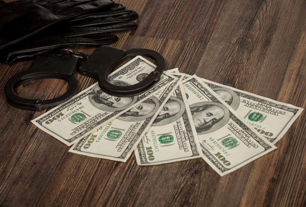Gloves, handcuffs and dollars on a table - Foto, imagen
