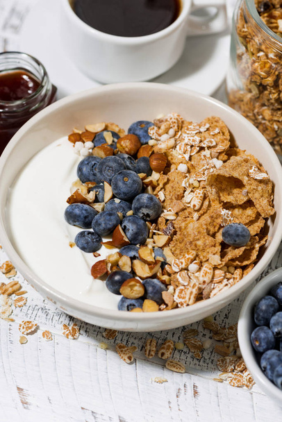 bowl of healthy wholegrain flakes, yogurt and fresh blueberries for breakfast, closeup - Fotó, kép