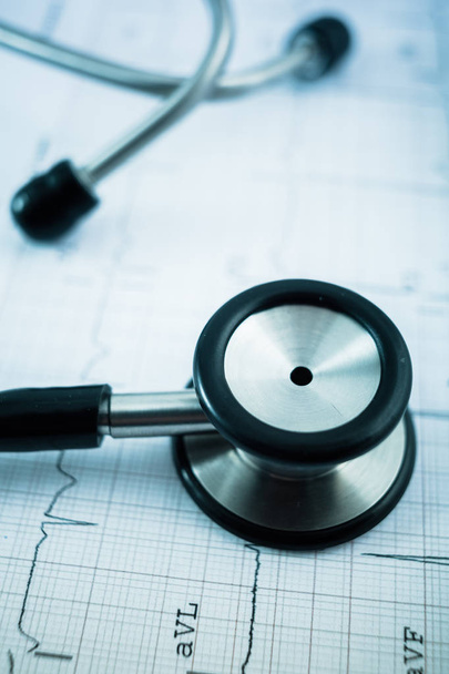 Stethoskop auf Kardiogramm-Konzept für die Herzpflege auf dem Schreibtisch.. - Foto, Bild