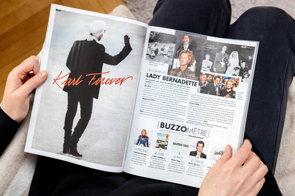 Woman reading newsapepr about Karl Lagerfeld death - Foto, Bild
