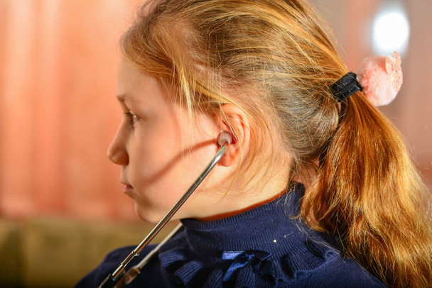 Dívka drží stetoskop v jeho rukou a poslouchá pacienta, domácí hru, u lékaře. - Fotografie, Obrázek