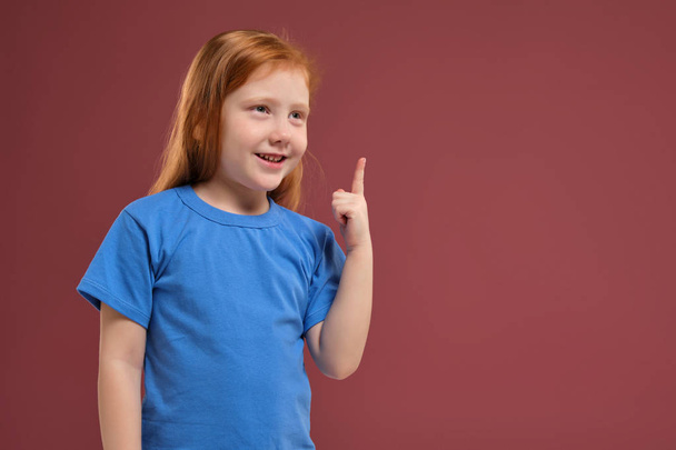 Portrait of cute redhead emotional little girl on red background - Foto, Bild
