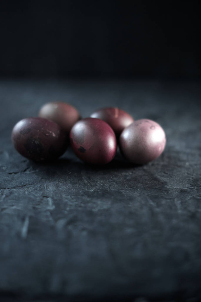 Dark purple eggs on a rough cement background - 写真・画像