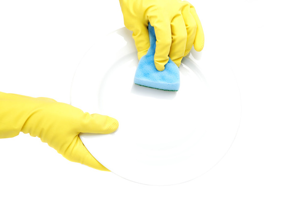 Hands in rubber gloves washing sponge the plate on a white backg - Photo, image