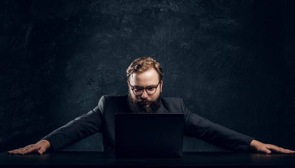 The bearded boss of the corporation looks into his laptop - Photo, Image