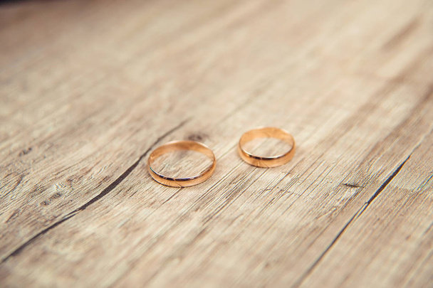 Arany eljegyzési gyűrűk. Ékszerek. Az esküvői szertartás. Esküvői. Esküvő gyűrű van egy fából készült asztal. - Fotó, kép