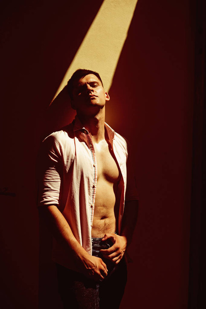 Handsome young man posing in open shirt showing torso - Foto, imagen