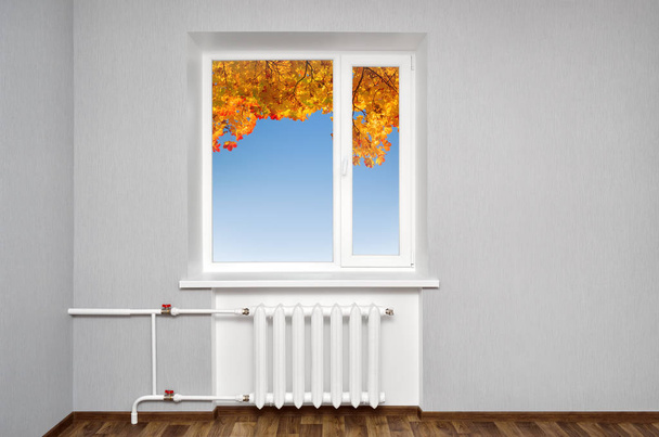 White window in empty room with heating and gray walls. Beautiful view from the window of the home. - Photo, Image