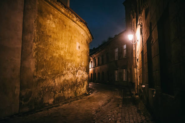 Antigua noche estrecha calle Vilnius con arquitectura antigua y fondo de invierno
 - Foto, imagen