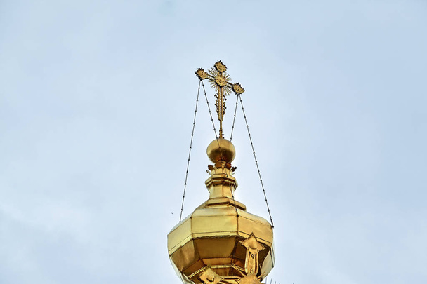 Eastern orthodox crosses on gold domes, cupolas, against blue sky with clouds - Photo, Image