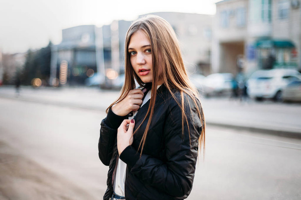 Girl wearing t-shirt and leather jacket posing against street , urban clothing style. Street photography - Fotoğraf, Görsel