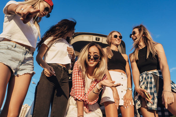 Pięć młodych kobiet miłej zabawy na parkingu. - Zdjęcie, obraz