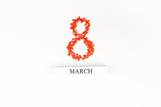 Creatieve plat lag bovenaanzicht 8 maart International Women's Day wenskaart met kleine rode harten op witte achtergrond. Viering briefkaart sjabloon - Foto, afbeelding