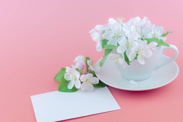 Concept créatif de tasse à café et de fleurs de pommier blanc sur fond rose avec maquette de carte postale et espace de copie dans un style minimal, modèle pour le texte
 - Photo, image