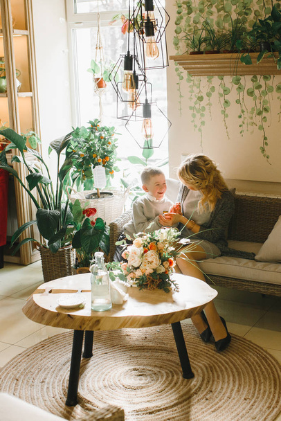 Moeder en dochter met bloemen in caffe. Zoon geven bloemen aan moeder. leuke familie. Internationale Vrouwendag, 8 maart vieren - Foto, afbeelding