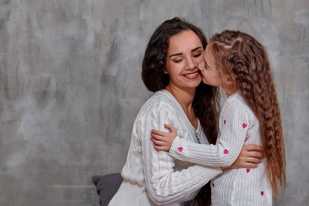 Emotionen einer schönen jungen Mutter und ihrer kleinen Tochter, die Zeit miteinander verbringen - Foto, Bild