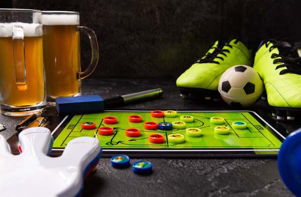 Image of two mugs of foam beer, table football, ball, rattle toy - Photo, Image