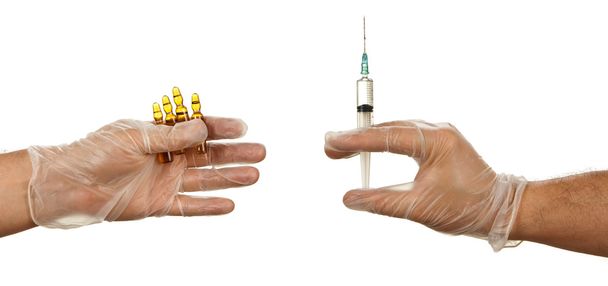 Рука держит ампулы с желтым наркотиком и латексной перчаткой
 - Фото, изображение