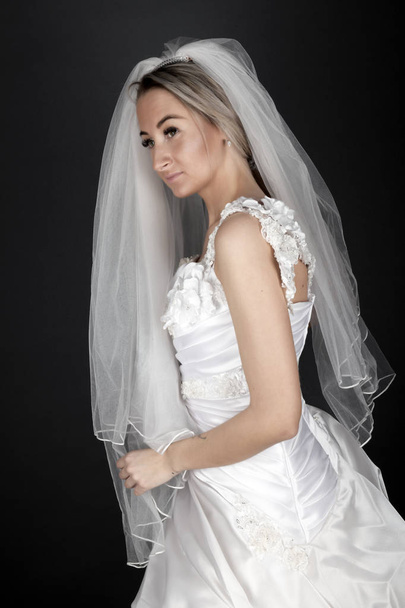 Beautiful blonde bride in a white dress on a black background - Fotoğraf, Görsel
