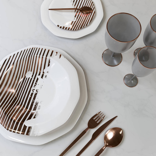 A beautiful set of dishes with a gold pattern. Plates, glasses, spoons, fork, knife on the table. 3D illustration. - 写真・画像