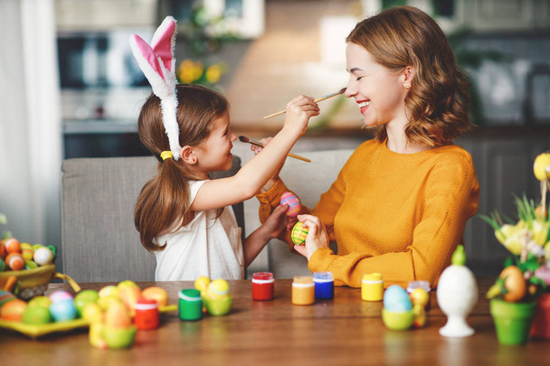 ¡Feliz Pascua! familia madre e hija hija con orejas liebre preparándose para holida
 - Foto, Imagen