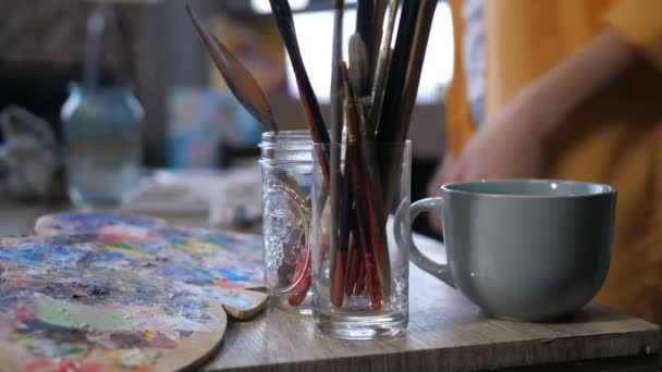 Artystycznego narzędzia i filiżankę gorącego napoju na stół roboczy - Materiał filmowy, wideo