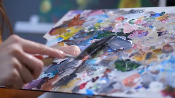 Pintor con cuchillo de paleta mezclando pinturas acrílicas
 - Metraje, vídeo