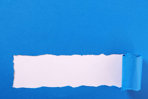 Torn blue paper strip curled edge border frame - Foto, Bild