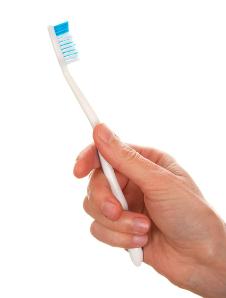 Рука жінки тримає зубну щітку
 - Фото, зображення