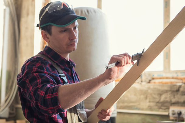 Pracovník provede měření na dřevěném prkénku - Fotografie, Obrázek
