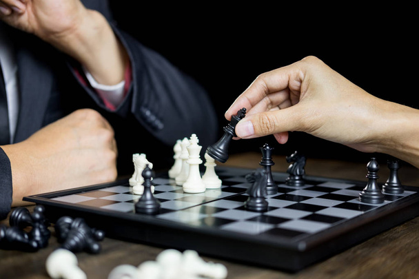 main de l'homme d'affaires figure d'échecs en mouvement dans le jeu d'échiquier de concurrence pour l'analyse du développement, la gestion d'idée de stratégie ou concept de leadership
 - Photo, image