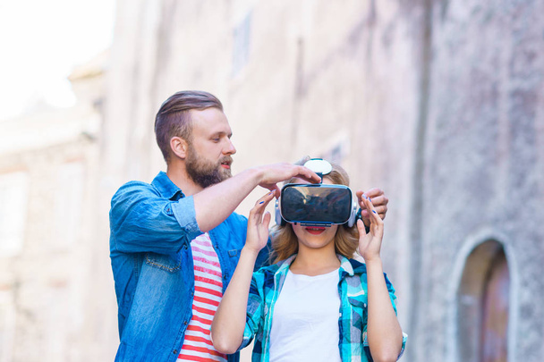 Couple marchant dans la rue en casque de réalité augmentée ou virtuelle. VR, AR, dispositifs de divertissement et concept technologique futuriste
. - Photo, image