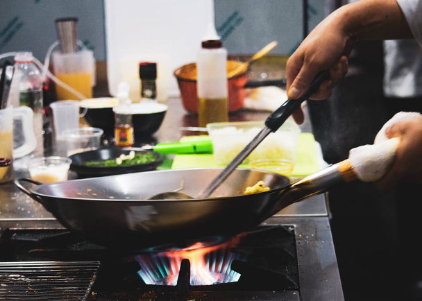 Szakács főzés élelmiszer-konyha, keverjük sült zöldségekkel a serpenyőben - Fotó, kép