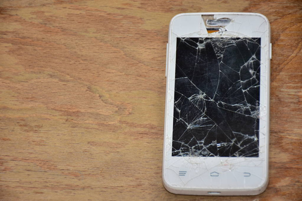 зламаний телефон на дерев'яному фоні
 - - Фото, зображення