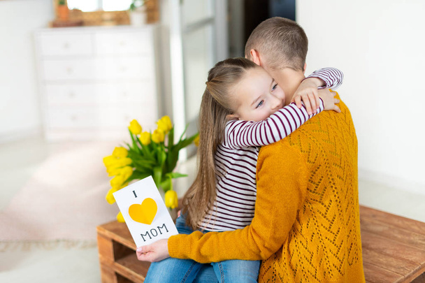 Adorable young girl giving her mom, young cancer patient, homemade I LOVE MOM greeting card. Family celebration concept. Happy Mother's Day or Birthday Background. - Fotografie, Obrázek