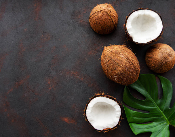 Kokosové ořechy se zelenými listy na černém pozadí - Fotografie, Obrázek