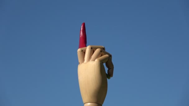 Rotating wooden manikin artist hand with red hot chili pepper on sky background - Footage, Video