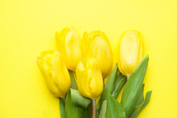 Bouquet of yellow tulips on a yellow background Copy space, - Zdjęcie, obraz
