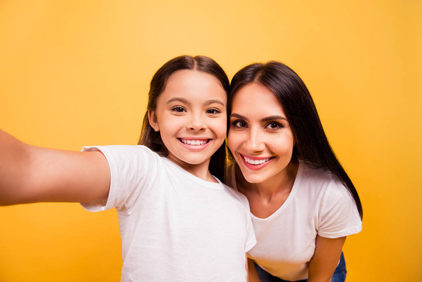 Self-portrait of nice cute lovely sweet adorable attractive charming cheerful people mommy mum mom pre-teen girl having fun day isolated over shine vivid pastel yellow background - 写真・画像
